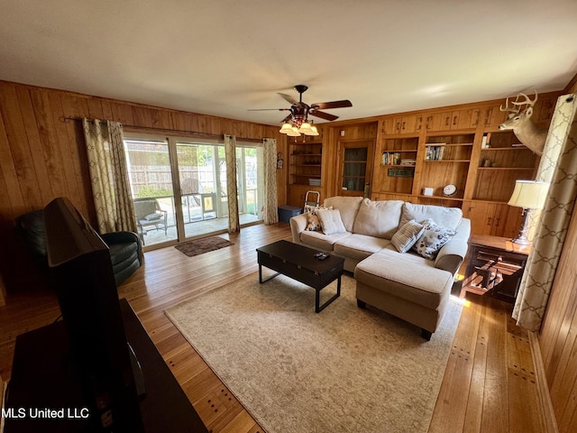 2293 Elm St, Hernando, MS 38632 - living room featuring wooden walls, hardwood / wood-style floors, ceiling fan, and built in shelves