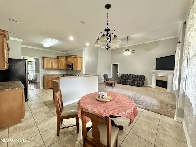 dining room with light tile patterned floors, light colored carpet, ornamental molding, and a fireplace