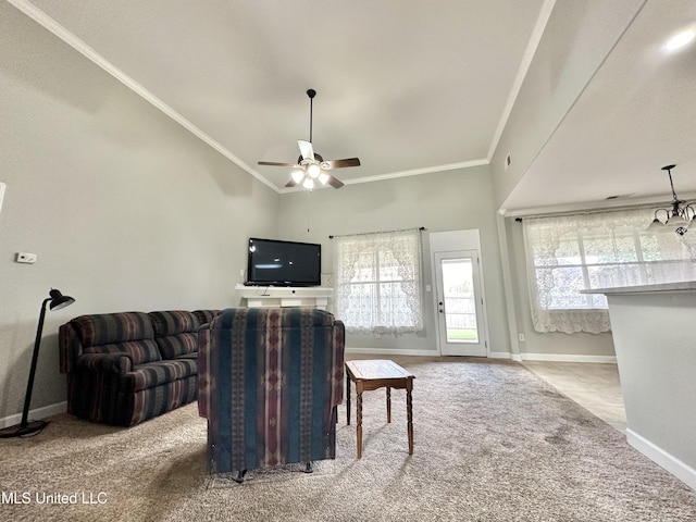 living room with ceiling fan, baseboards, crown molding, and carpet