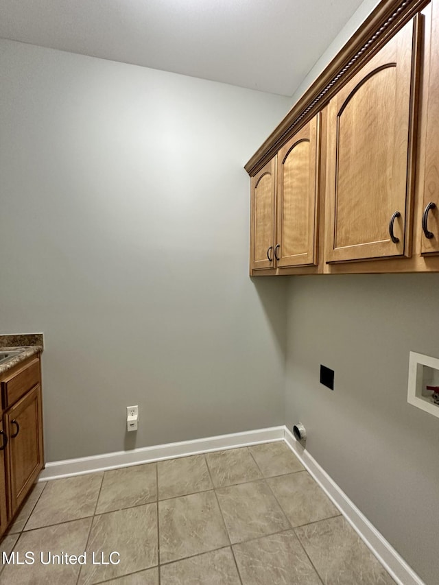 clothes washing area with light tile patterned floors, baseboards, cabinet space, and washer hookup