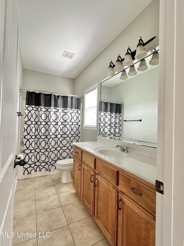 bathroom with vanity, a shower with shower curtain, visible vents, tile patterned floors, and toilet