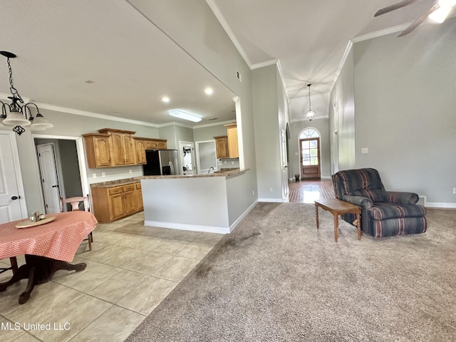 kitchen with light tile patterned flooring, ornamental molding, stainless steel refrigerator with ice dispenser, light colored carpet, and open floor plan