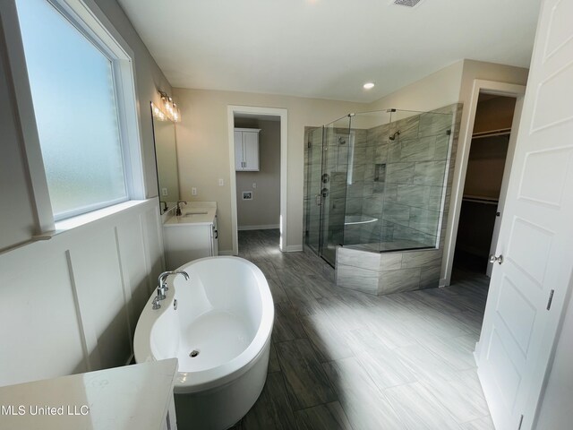 bathroom with separate shower and tub, vanity, and hardwood / wood-style flooring