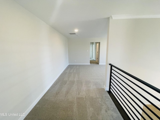 corridor with crown molding and light colored carpet