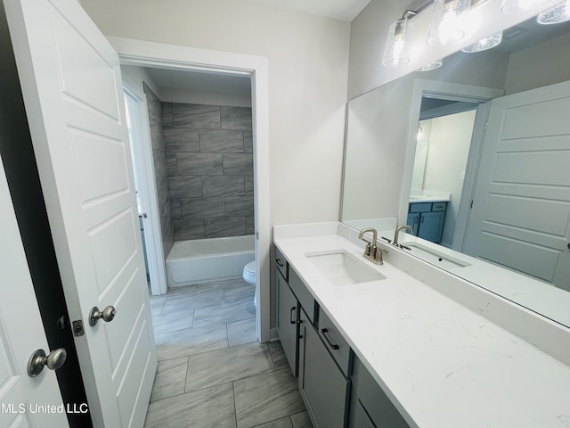 full bathroom featuring toilet, vanity, and tiled shower / bath combo