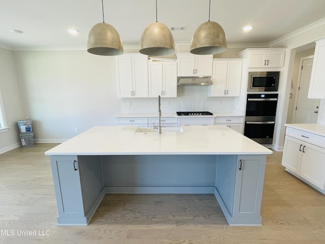 kitchen with sink, white cabinetry, a kitchen island with sink, hanging light fixtures, and black appliances