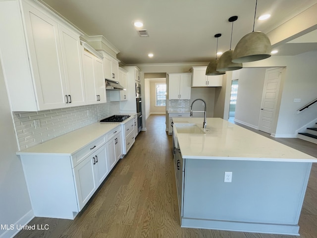 kitchen featuring a kitchen island with sink, white cabinetry, pendant lighting, and sink