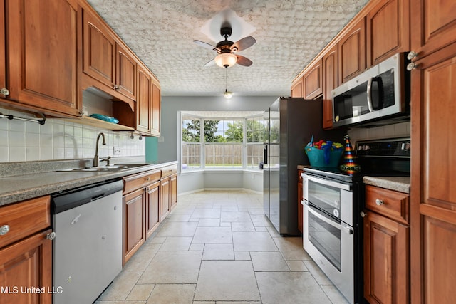 120 Pitcher Pt, Long Beach, MS 39560 - kitchen with appliances with stainless steel finishes, a sink, decorative backsplash, baseboards, and a ceiling fan