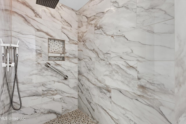 bathroom featuring a marble finish shower