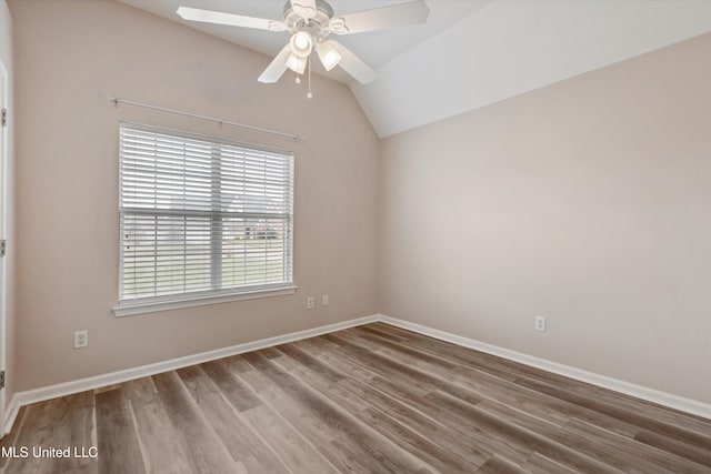 spare room featuring baseboards, a ceiling fan, lofted ceiling, and wood finished floors