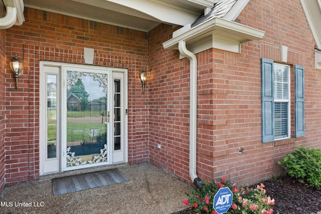 property entrance featuring brick siding