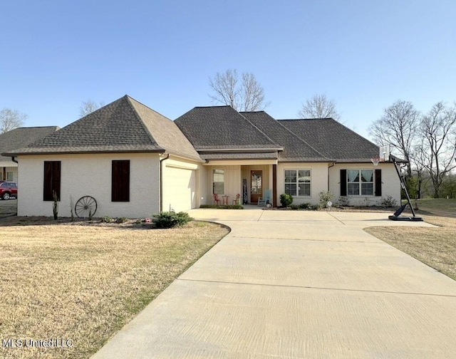 ranch-style house featuring a front yard, an attached garage, driveway, and roof with shingles