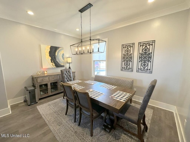 dining area with ornamental molding, wood finished floors, recessed lighting, an inviting chandelier, and baseboards