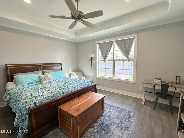 bedroom featuring ornamental molding, a tray ceiling, dark wood-style floors, recessed lighting, and baseboards