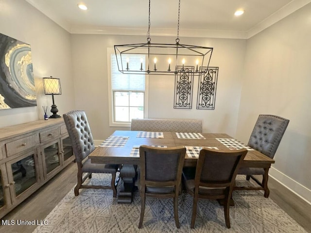 dining area featuring an inviting chandelier, ornamental molding, baseboards, and wood finished floors