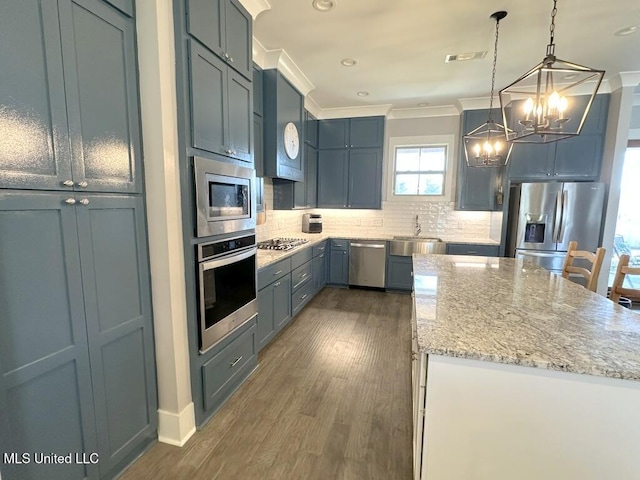 kitchen featuring visible vents, a sink, appliances with stainless steel finishes, crown molding, and a chandelier