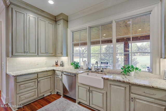 kitchen featuring tasteful backsplash, sink, wood-type flooring, cream cabinetry, and dishwasher