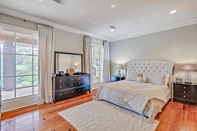 bedroom with multiple windows, light hardwood / wood-style floors, and ornamental molding