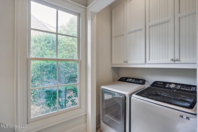 clothes washing area featuring cabinets and washing machine and dryer