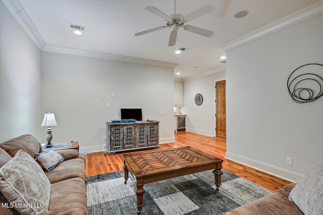 living room featuring ceiling fan, wood-type flooring, and crown molding