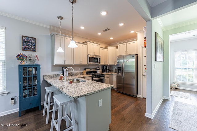 6750 Whooper Swan Dr, Olive Branch, MS 38654 - kitchen with appliances with stainless steel finishes, a sink, ornamental molding, a peninsula, and light stone countertops