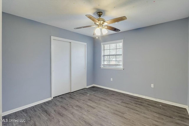 unfurnished bedroom featuring hardwood / wood-style flooring, ceiling fan, and a closet