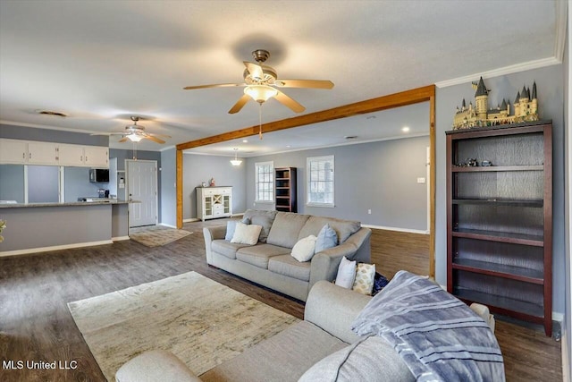 living room with dark hardwood / wood-style flooring, crown molding, and ceiling fan