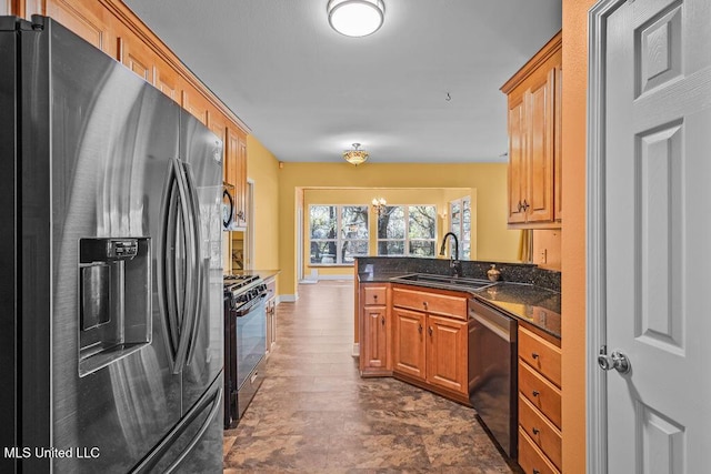 kitchen featuring baseboards, brown cabinets, a peninsula, stainless steel appliances, and a sink