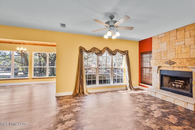 unfurnished living room featuring visible vents, ceiling fan with notable chandelier, a stone fireplace, and baseboards