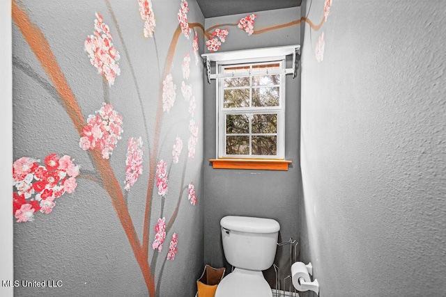 bathroom with toilet and a textured wall