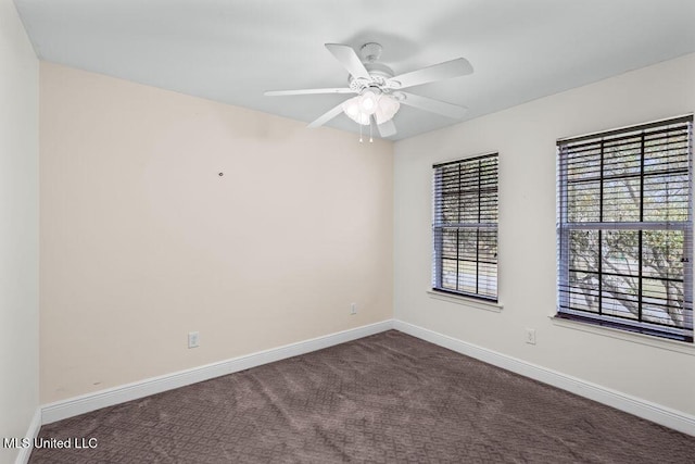 unfurnished room featuring dark carpet, a ceiling fan, and baseboards