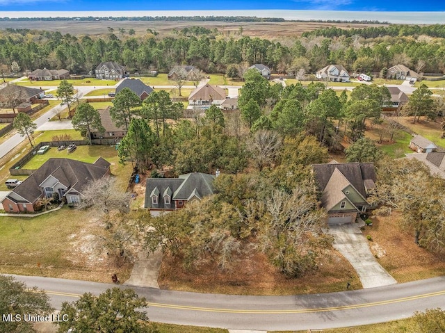 drone / aerial view featuring a view of trees and a residential view