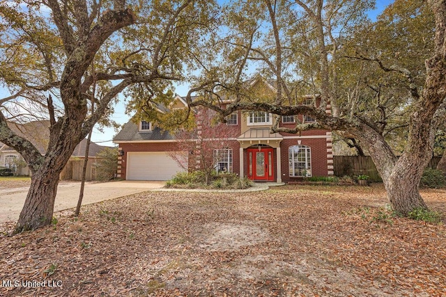 view of front of home with brick siding, an attached garage, concrete driveway, and fence