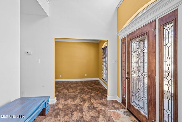 foyer with stone finish floor and baseboards