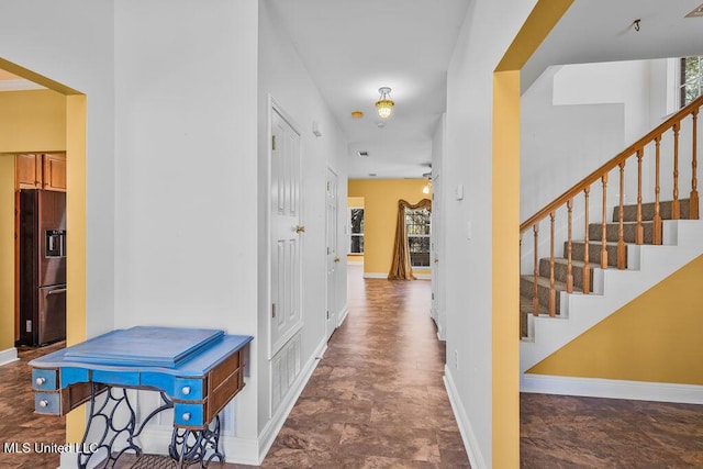 hallway featuring stairway and baseboards