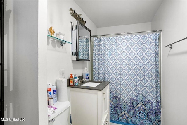 bathroom with vanity, toilet, and walk in shower