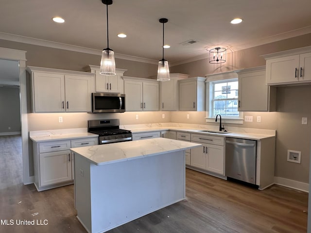 kitchen with stainless steel appliances, a center island, pendant lighting, and white cabinets