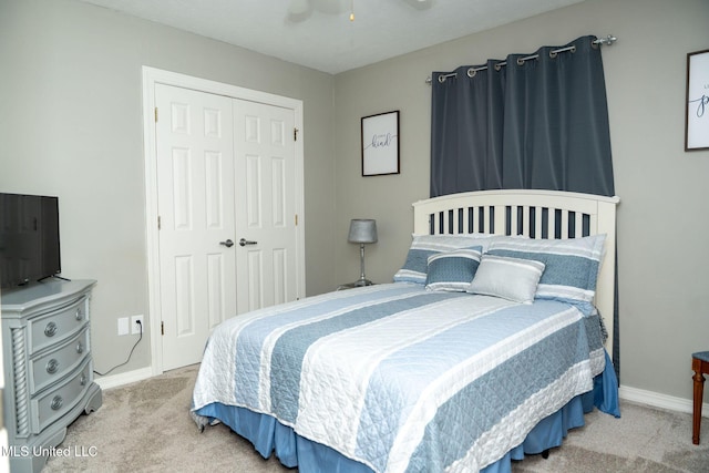 carpeted bedroom with a closet, a ceiling fan, and baseboards