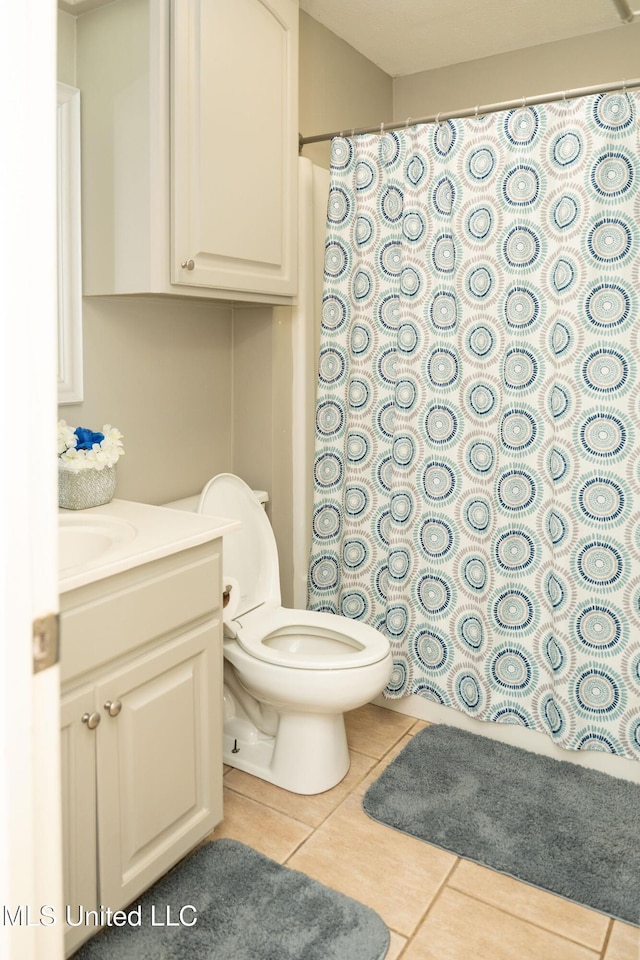 bathroom featuring tile patterned flooring, toilet, vanity, and a shower with shower curtain