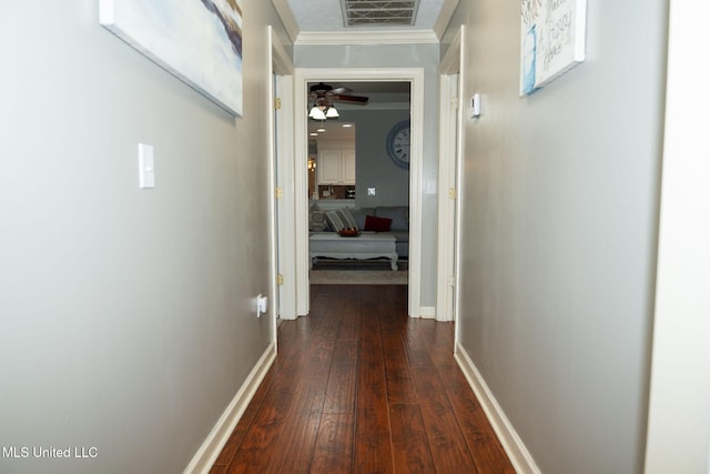 hall with crown molding, dark wood-style flooring, visible vents, and baseboards