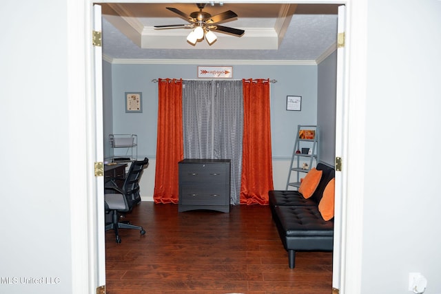 office space with a textured ceiling, wood finished floors, a ceiling fan, a raised ceiling, and crown molding