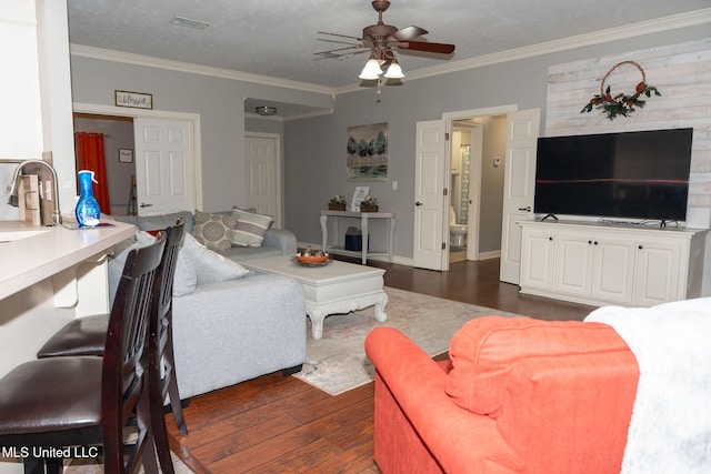 living room featuring ceiling fan, dark wood-style flooring, and crown molding