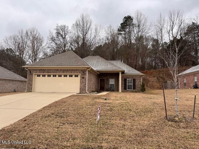 view of front of property with a front yard and a garage