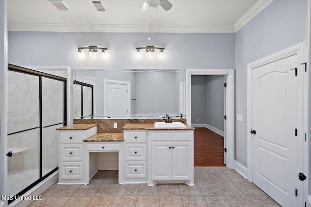 bathroom with vanity, ornamental molding, a shower with shower door, and tile patterned flooring