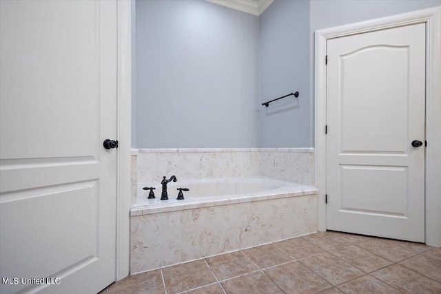 bathroom with ornamental molding, tiled tub, and tile patterned flooring