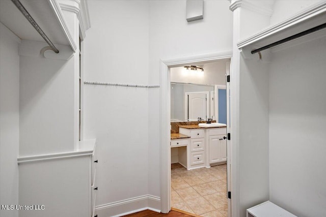 spacious closet featuring sink and light tile patterned floors