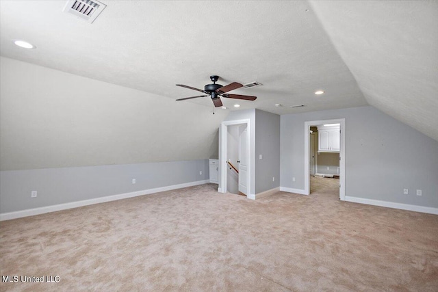 bonus room with lofted ceiling, light carpet, a textured ceiling, and ceiling fan