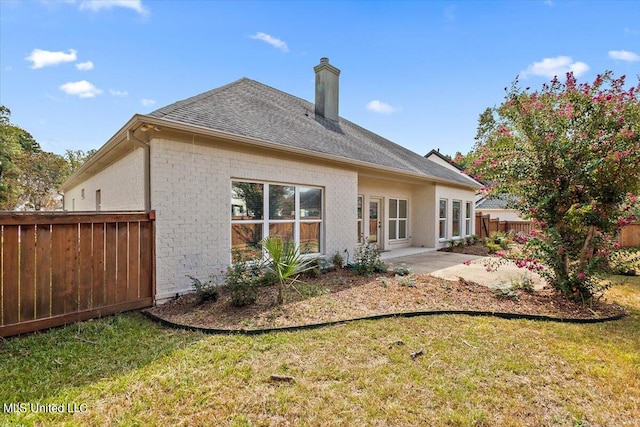 back of property featuring a patio area and a yard