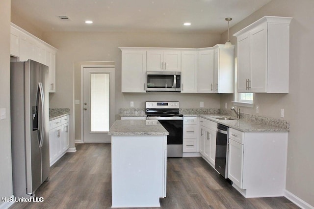 kitchen featuring a center island, dark wood finished floors, visible vents, a sink, and appliances with stainless steel finishes