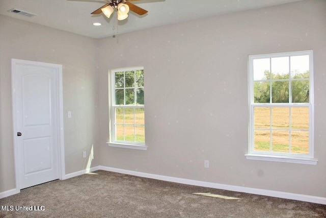 unfurnished room featuring carpet, visible vents, baseboards, and ceiling fan